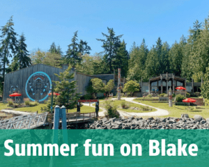 Longhouse building, blue sky, and path leading to front door and trees in the background