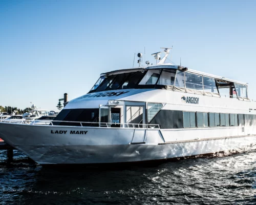 Photo of a white private charter boat on the water. It is named Lady Mary and has the Argosy Cruises branding on the side.